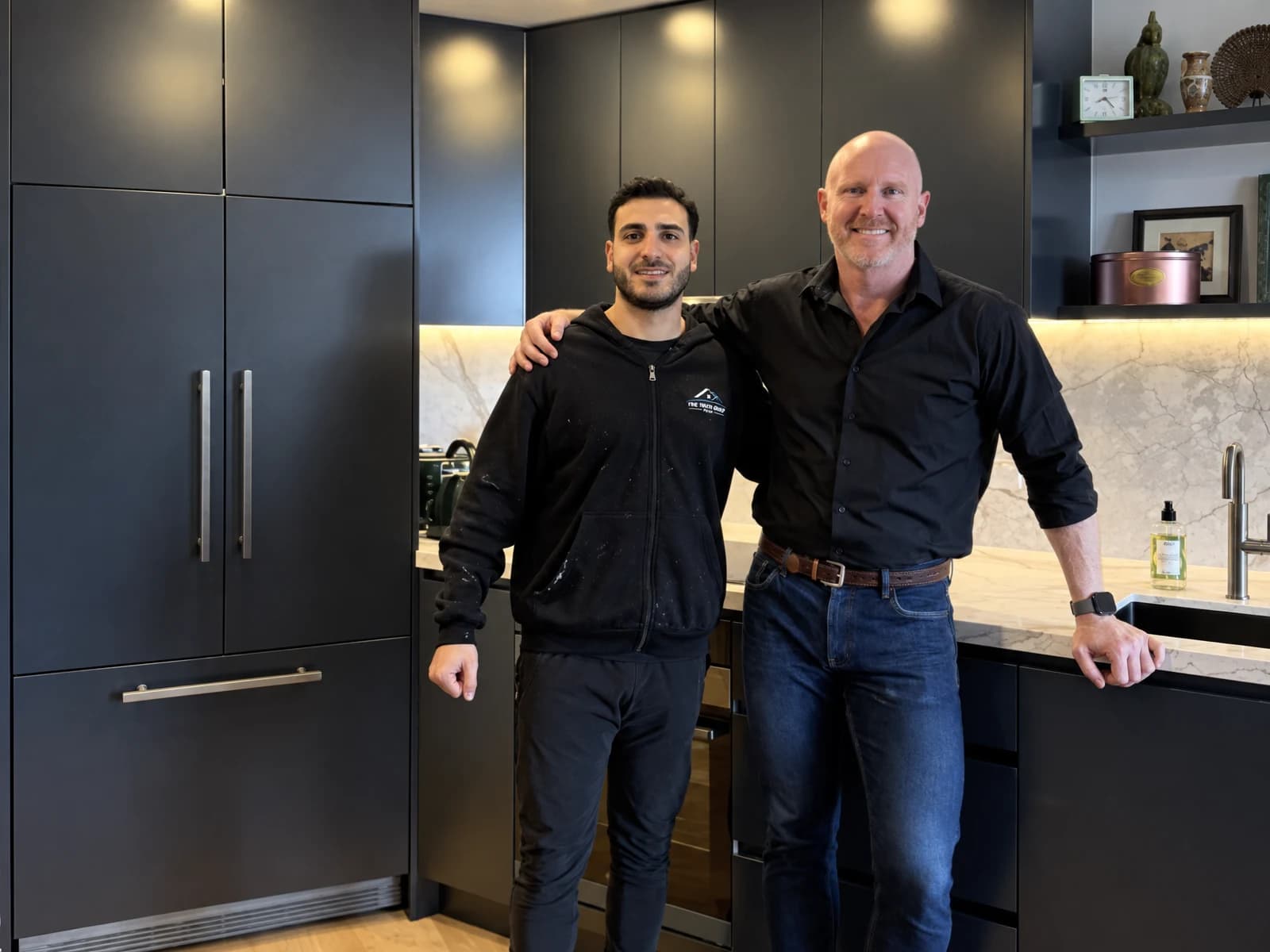 Richard Bechara of Fine Touch Group with a smiling homeowner in their finished black kitchen