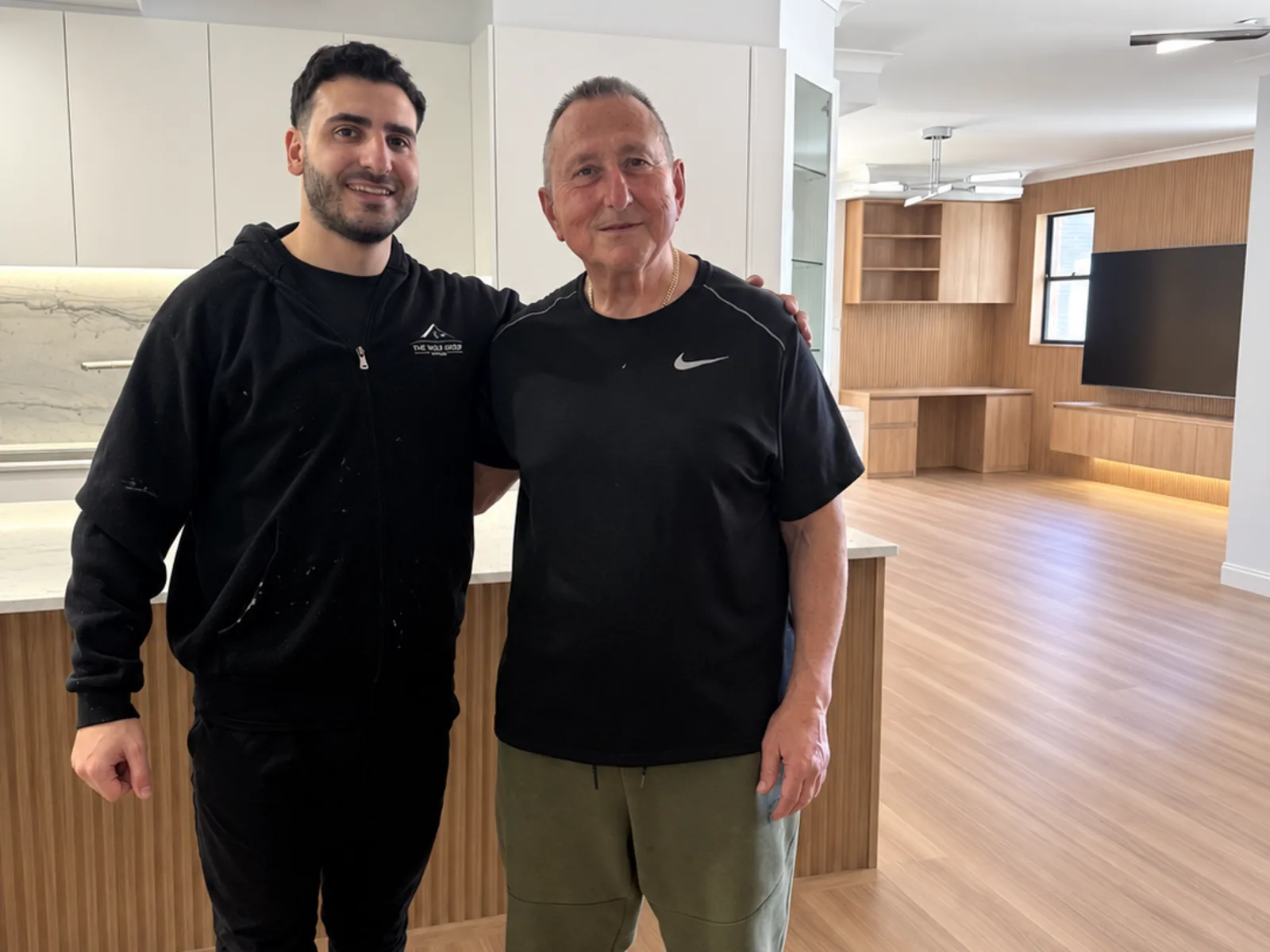 Richard Bechara of Fine Touch Group with a homeowner in their finished open-plan kitchen and living room